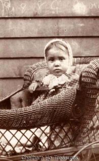 Antique cabinet photo little baby peering out of wicker stroller