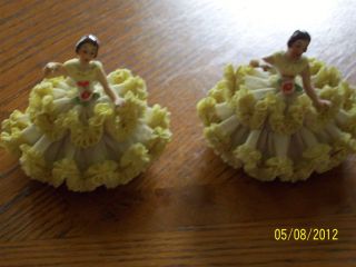 Dresden lace figurines wearing yellow and sitting on chair two