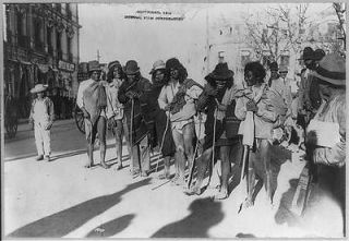 ,191 3 1914: poorly dressed Indians in a row with walking stick